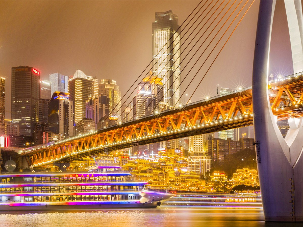 Chongqing evening cruise under a lit bridge